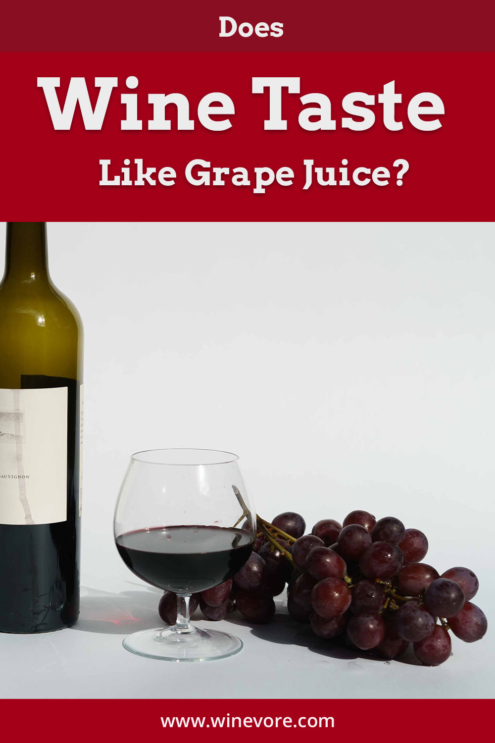 Wine bottle and glass on a white surface with grapes nearby - Does Wine Taste Like Grape Juice?