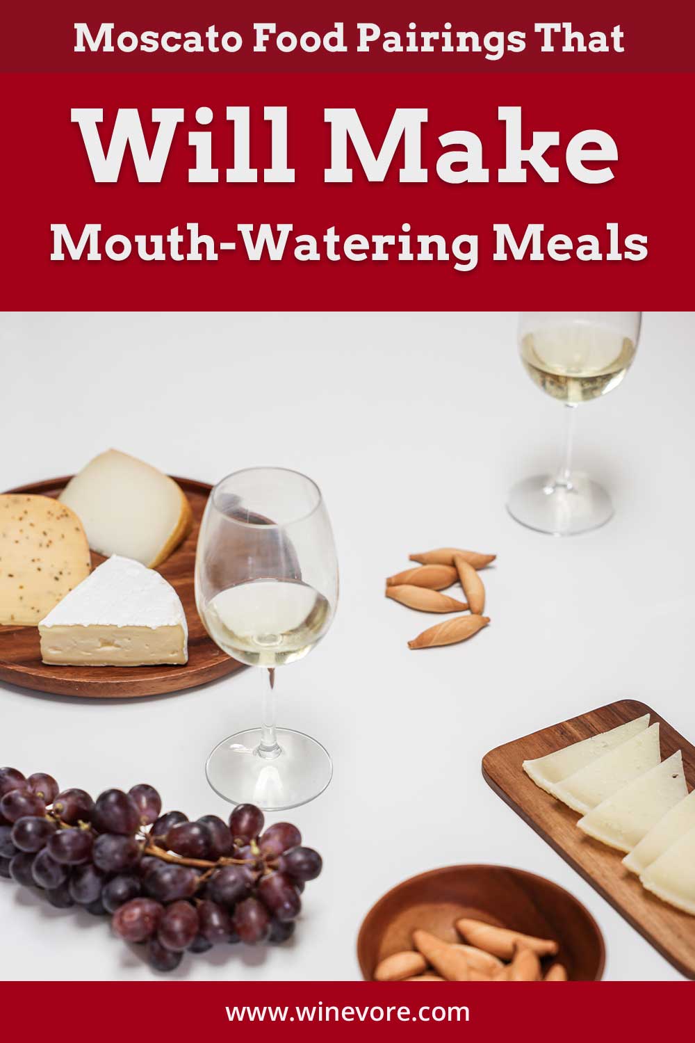 A wine glass with cheese and grapes on a white surface - Moscato Food Pairings.