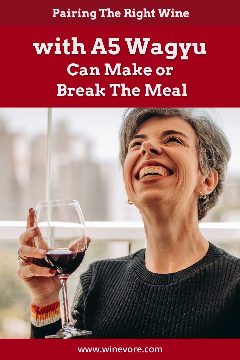 Woman with a wine glass in hand smiling looking up - Pairing The Right Wine with A5 Wagyu.