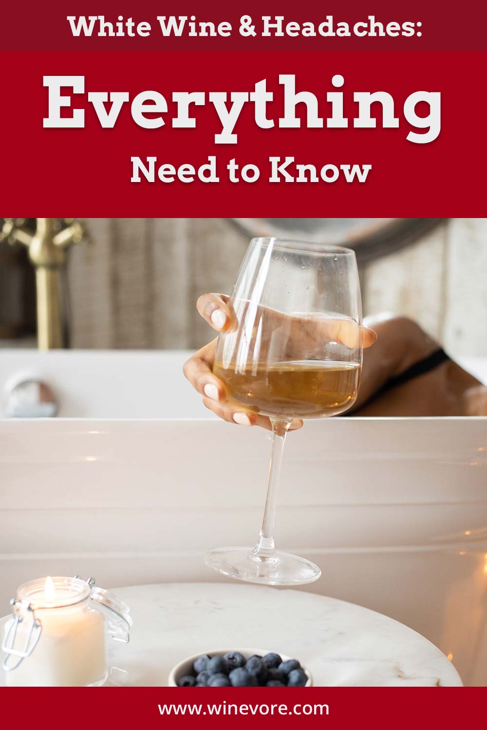 Person in a bathtub grabbing a wine glass from a table with a candle and berries on it - White Wine & Headaches.