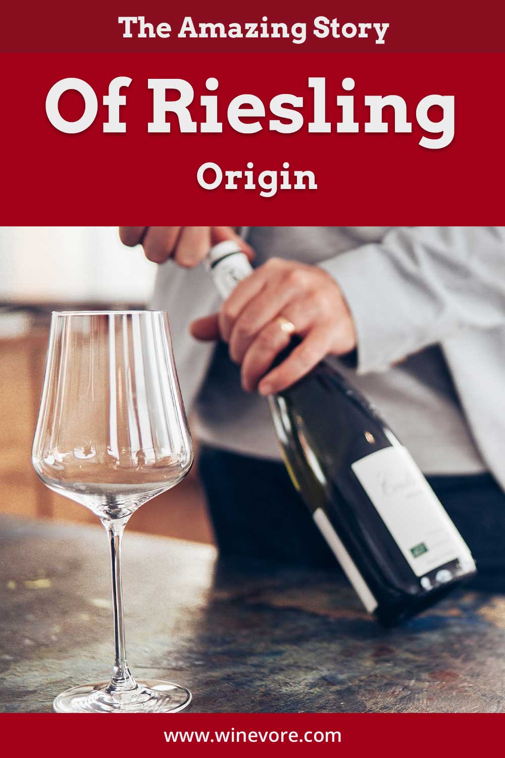 Man opening a wine bottle with a wine glass in front of him - Riesling Origin.