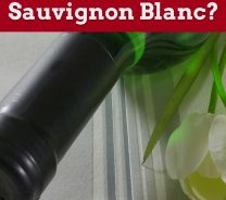 Green colour wine bottle and flower beside on white surface - What Is Sauvignon Blanc?